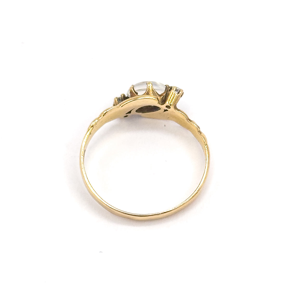 Viewed through the open circle of the band from behind, the underside of the setting and gallery visible with the cabochon and a diamond just showing above the shank.
