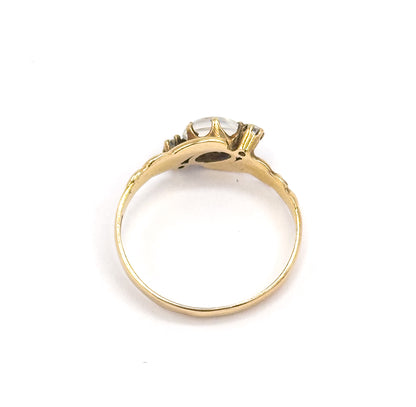 Viewed through the open circle of the band from behind, the underside of the setting and gallery visible with the cabochon and a diamond just showing above the shank.