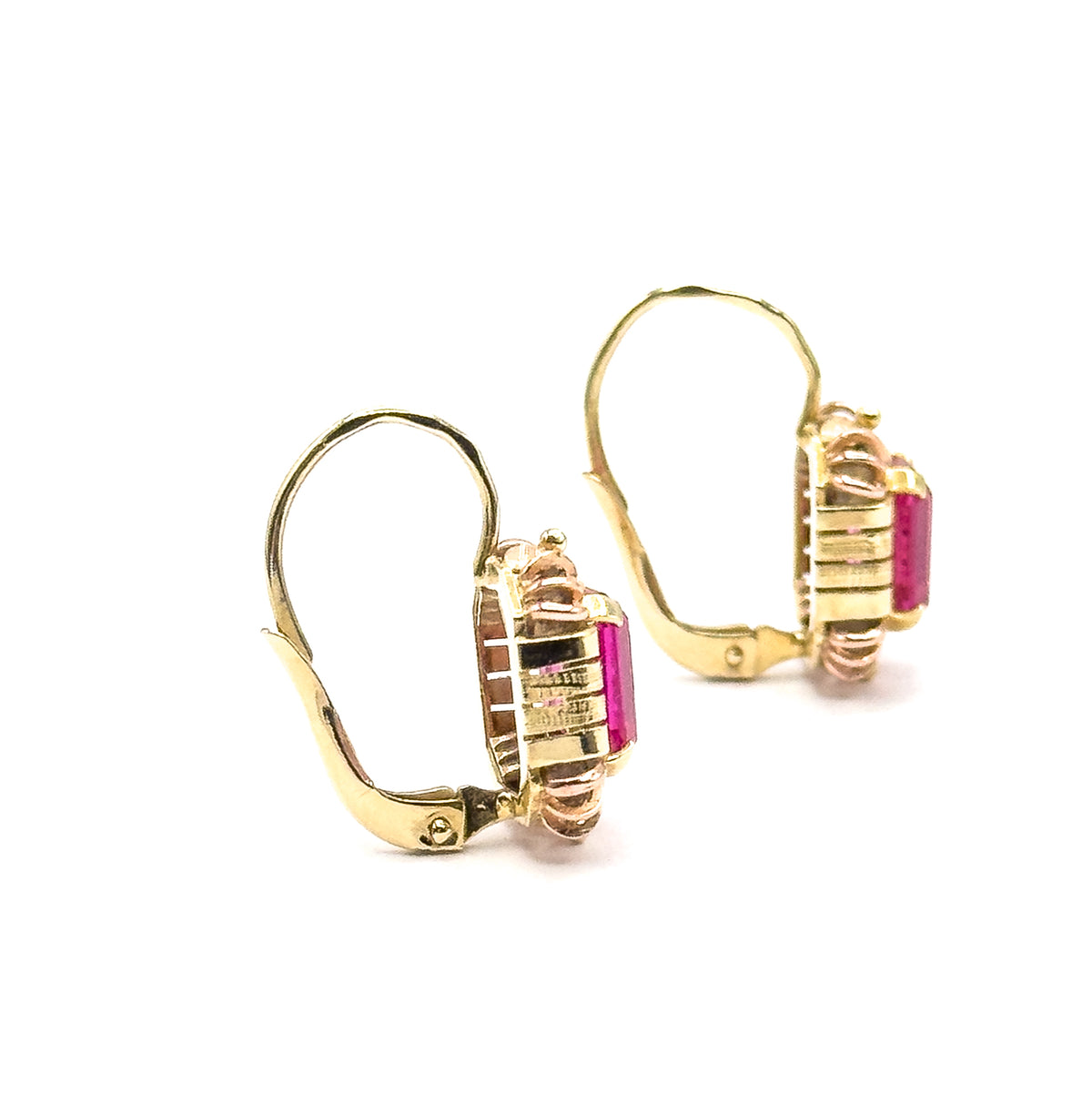 Angled profile of the pair showing the ribbed yellow frames edge-on, the deep pink stones just visible at the sides and the rose-gold prongs curling over, with both hinged hook fittings swung open.
