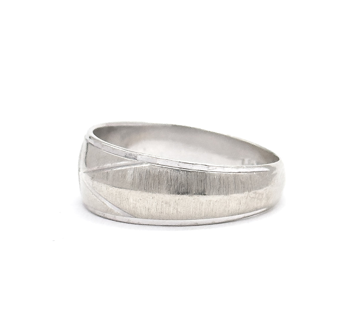 Side-on profile against white, the band lying nearly flat so the brushed textured face and its diagonal engraved line sweep across, with the hoop's width tapering down to the slim shank.