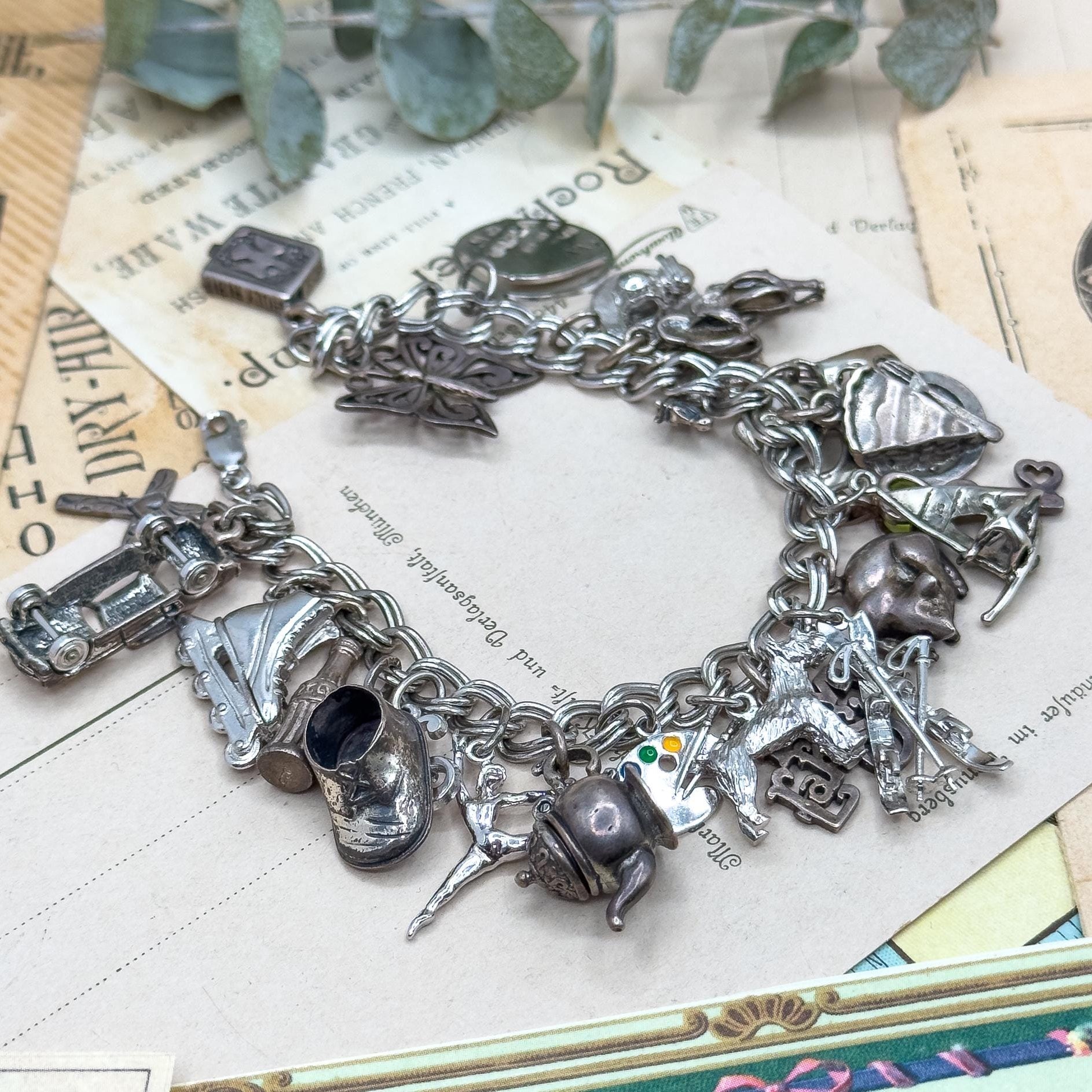 Silver charm bracelet on a vintage newspaper background