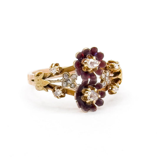 Gold ring with purple floral and diamond accents on a white background