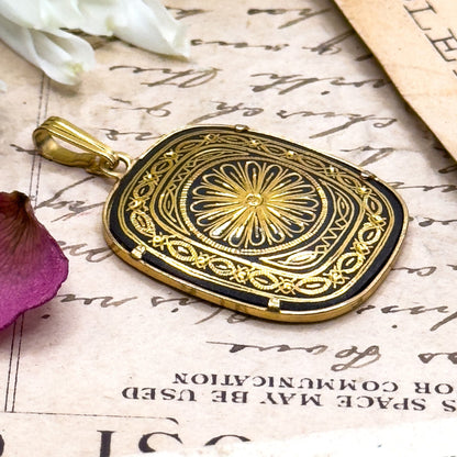 Decorative gold and black pendant on an old document with flowers