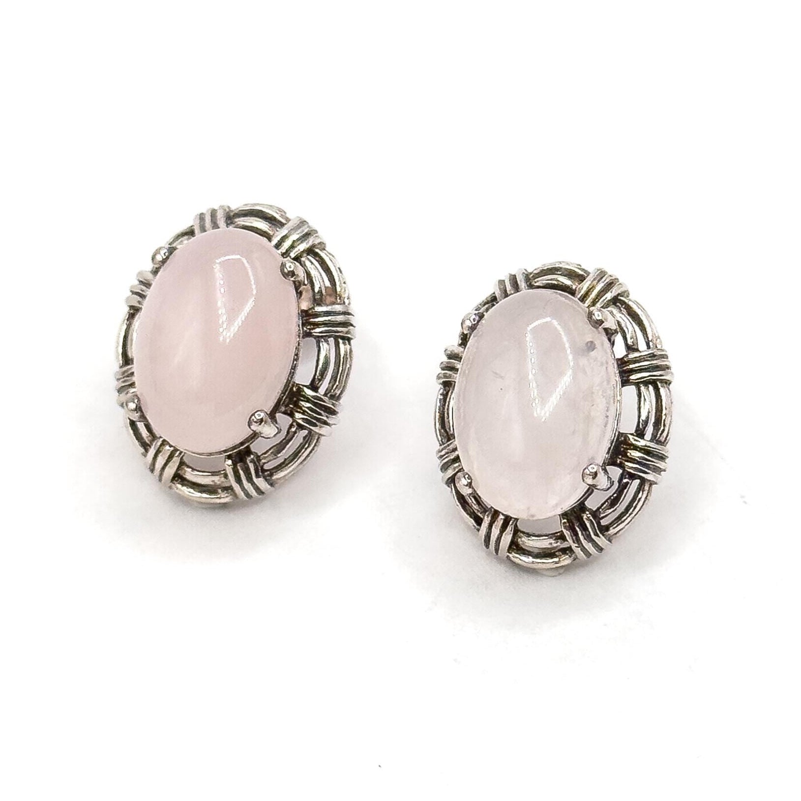 Pair of silver earrings with pink stones on a white background