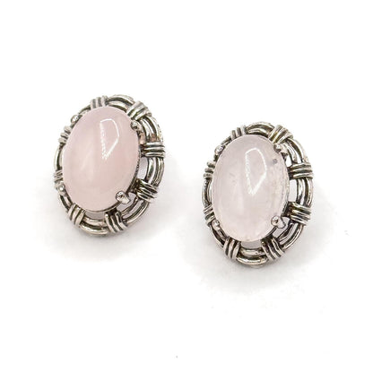 Pair of silver earrings with pink stones on a white background