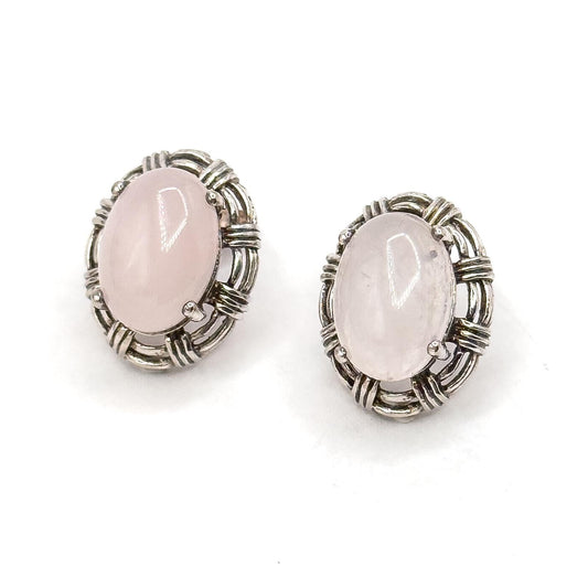 Pair of silver earrings with pink stones on a white background