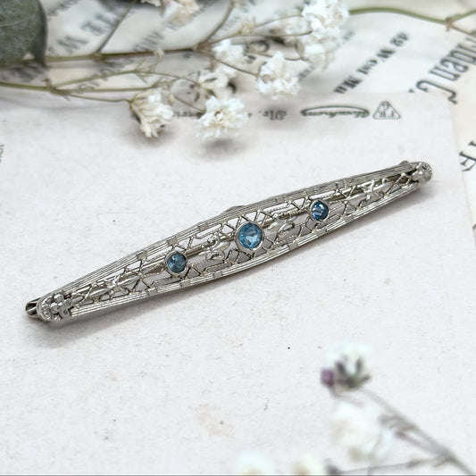 Silver hair clip with blue stones on a vintage paper background