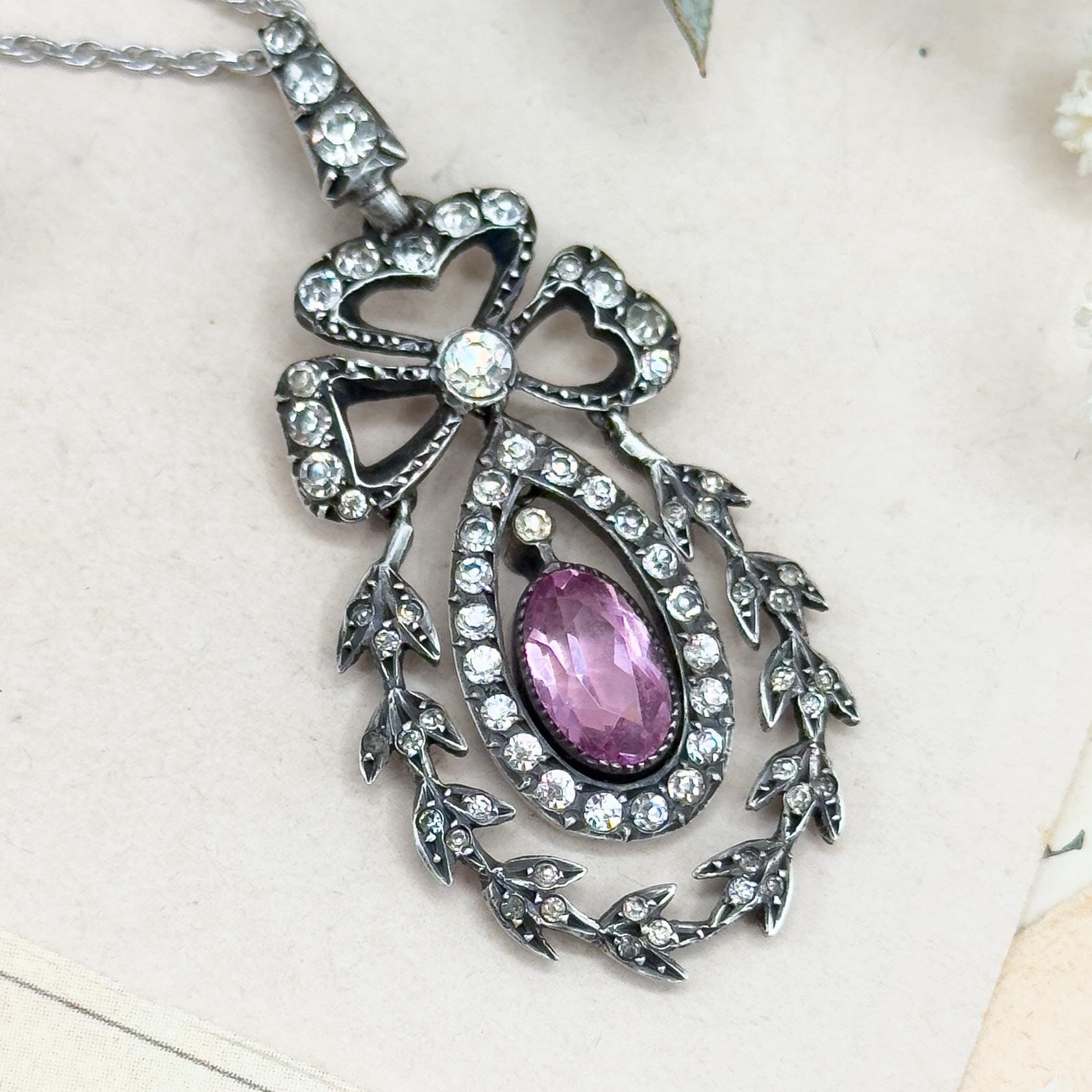 Decorative necklace with a purple gemstone on a light background