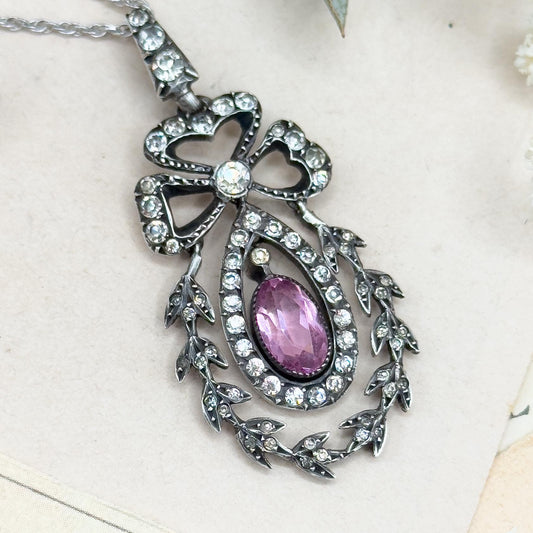 Decorative necklace with a purple gemstone on a light background