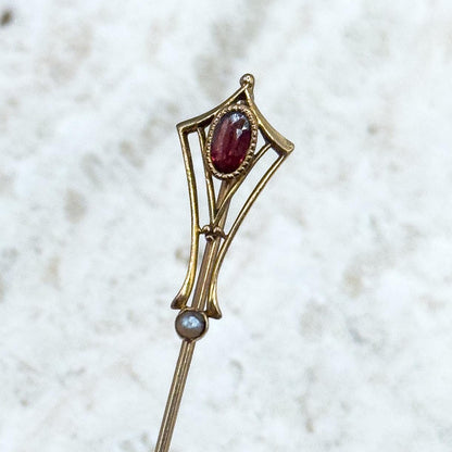 Decorative stickpin with gemstones on a textured white background